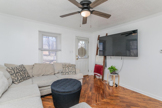 living room with ornamental molding, a ceiling fan, a textured ceiling, baseboards, and parquet flooring