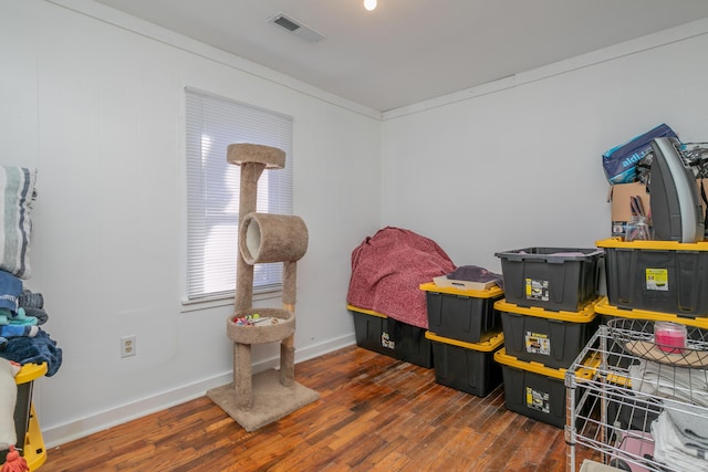 bedroom featuring wood finished floors, visible vents, and baseboards