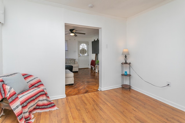 sitting room featuring baseboards, ceiling fan, wood finished floors, and crown molding