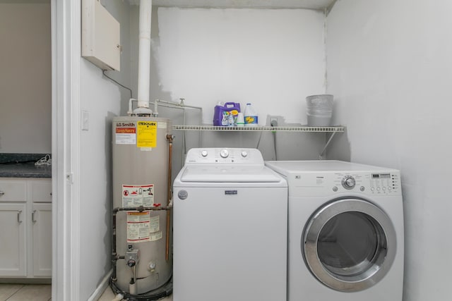 clothes washing area with laundry area, water heater, and washer and clothes dryer