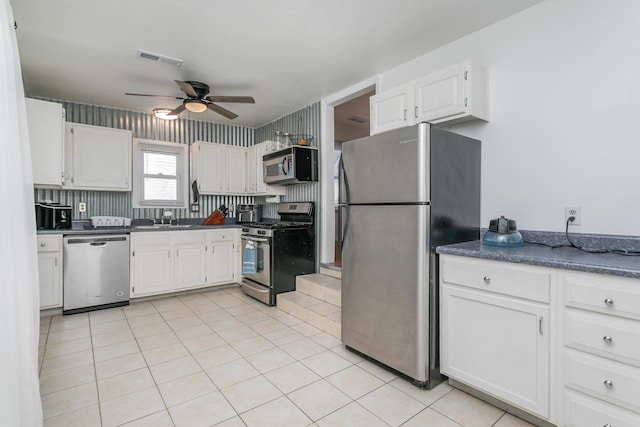 kitchen featuring light tile patterned floors, visible vents, dark countertops, appliances with stainless steel finishes, and white cabinetry