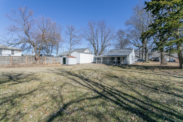 view of yard with an outdoor structure, fence, and a storage unit