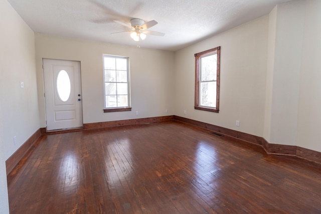 entryway featuring baseboards, wood-type flooring, visible vents, and a healthy amount of sunlight