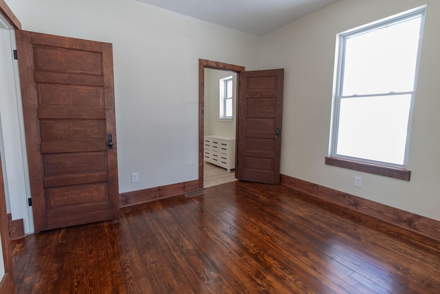 unfurnished room with baseboards and hardwood / wood-style floors