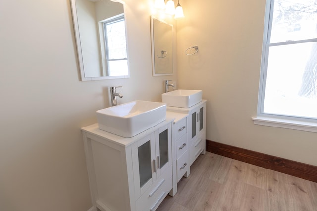 bathroom featuring plenty of natural light, a sink, and wood finished floors