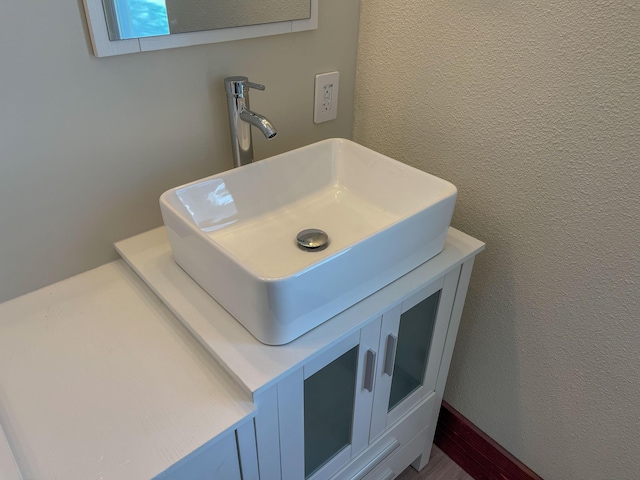 interior details with a textured wall and vanity