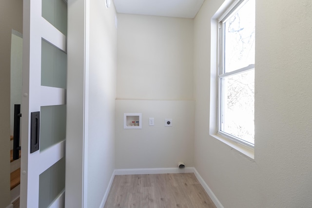 clothes washing area with laundry area, baseboards, light wood-style flooring, hookup for an electric dryer, and washer hookup