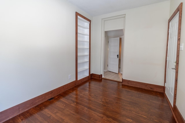 unfurnished bedroom featuring dark wood-type flooring and baseboards