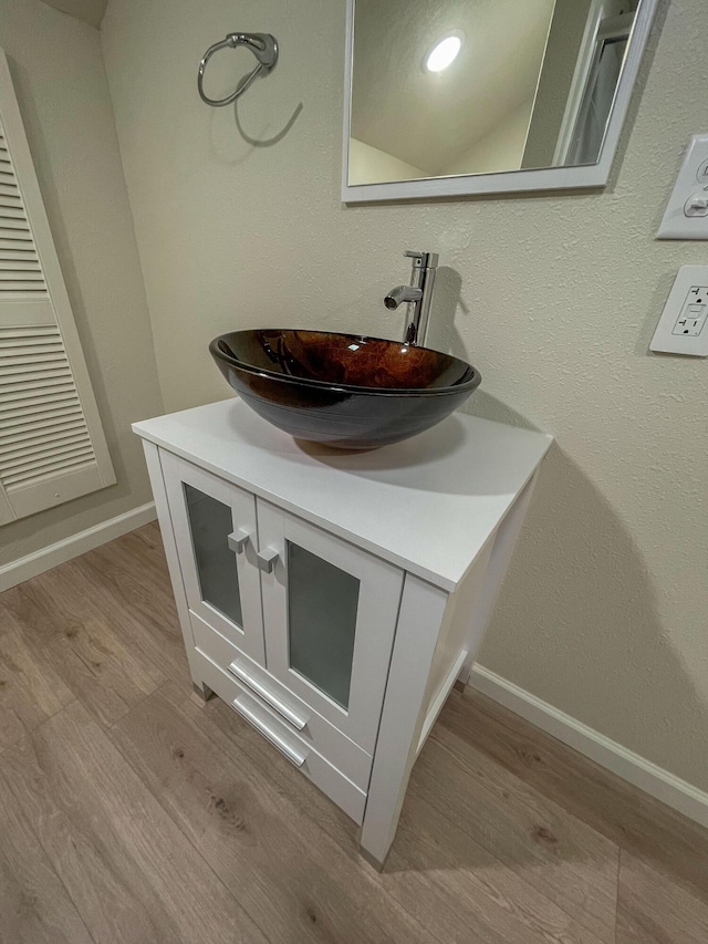 details featuring wood finished floors, vanity, and baseboards