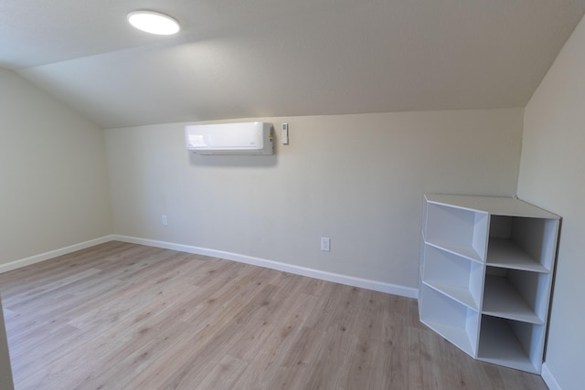 bonus room with a wall mounted air conditioner, vaulted ceiling, baseboards, and wood finished floors