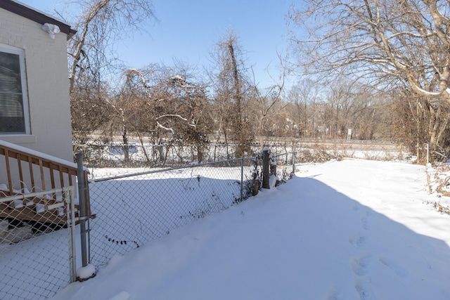 yard layered in snow featuring fence