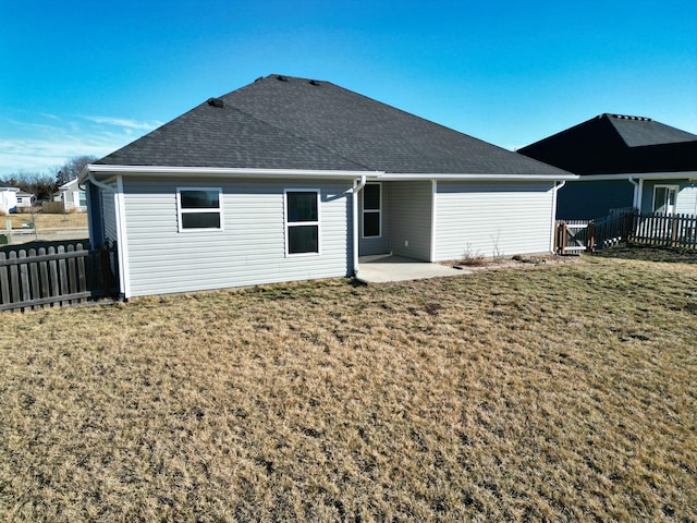 back of property featuring a patio area, fence, a lawn, and roof with shingles