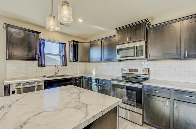 kitchen with visible vents, stainless steel appliances, dark brown cabinets, pendant lighting, and a sink