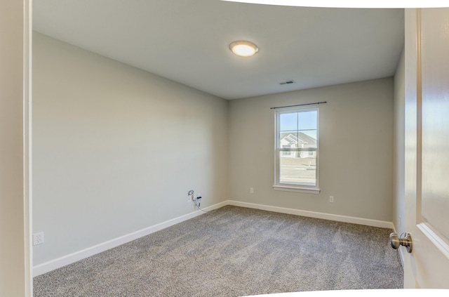 unfurnished room with carpet floors, visible vents, and baseboards