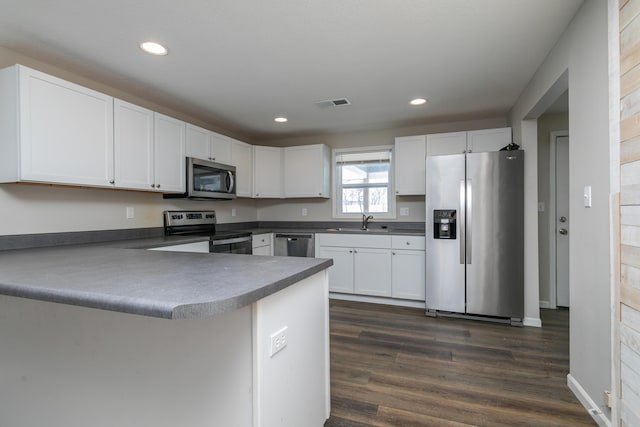 kitchen featuring stainless steel appliances, visible vents, white cabinetry, a sink, and a peninsula