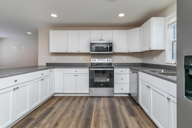 kitchen with appliances with stainless steel finishes, dark countertops, and white cabinetry