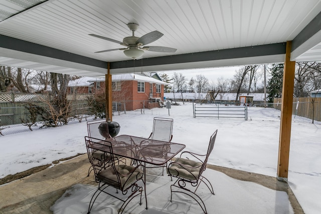 snow covered patio with fence and a ceiling fan