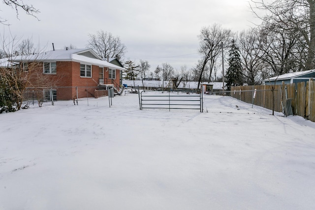 yard layered in snow featuring a fenced front yard