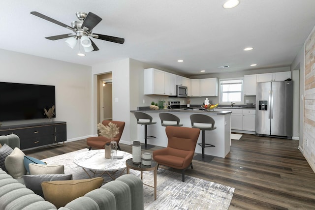 living room with baseboards, ceiling fan, dark wood-type flooring, and recessed lighting