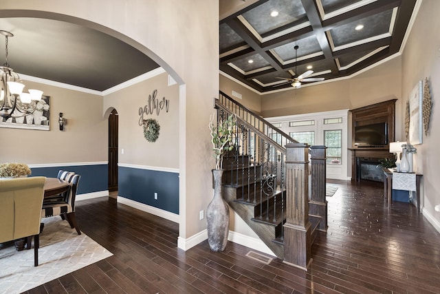 dining space featuring crown molding, a glass covered fireplace, wood finished floors, coffered ceiling, and baseboards