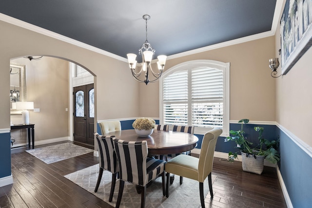 dining space featuring arched walkways, hardwood / wood-style flooring, and a wealth of natural light