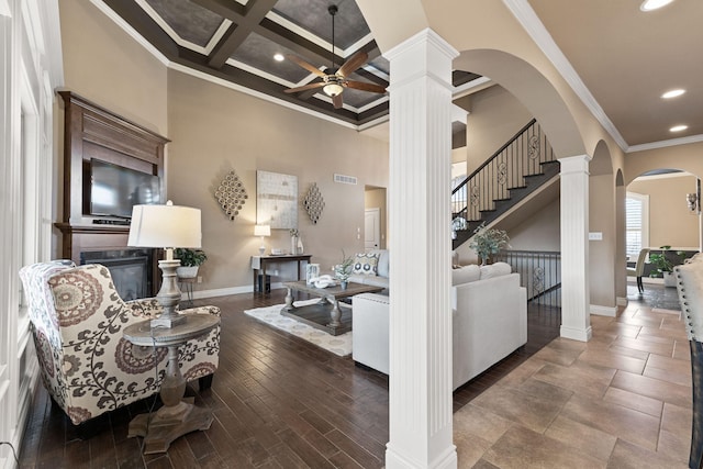 living area with visible vents, a high ceiling, ornamental molding, coffered ceiling, and ornate columns