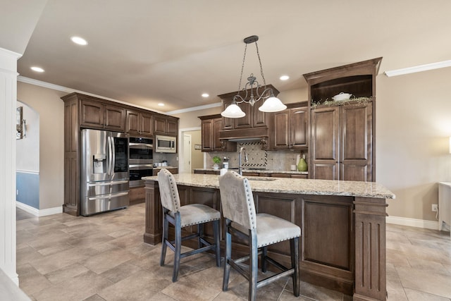 kitchen featuring decorative backsplash, ornamental molding, stainless steel appliances, dark brown cabinets, and a sink