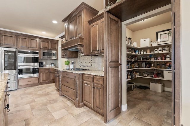 kitchen featuring recessed lighting, stainless steel appliances, custom exhaust hood, light stone countertops, and tasteful backsplash