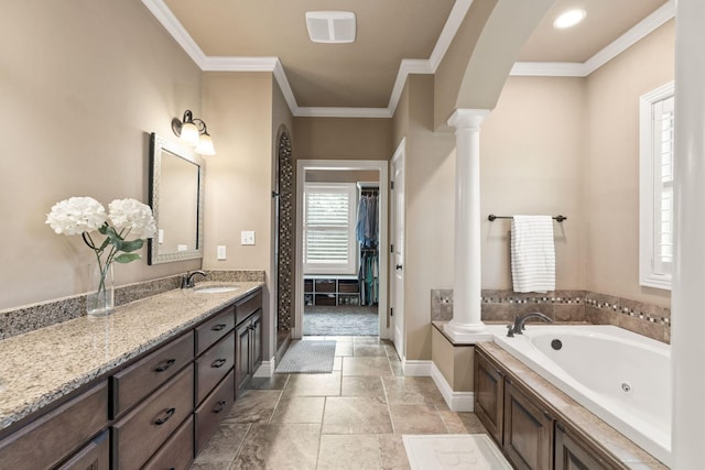 full bath with a walk in closet, crown molding, vanity, a jetted tub, and ornate columns