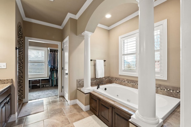 full bathroom with ornamental molding, a wealth of natural light, a jetted tub, and ornate columns