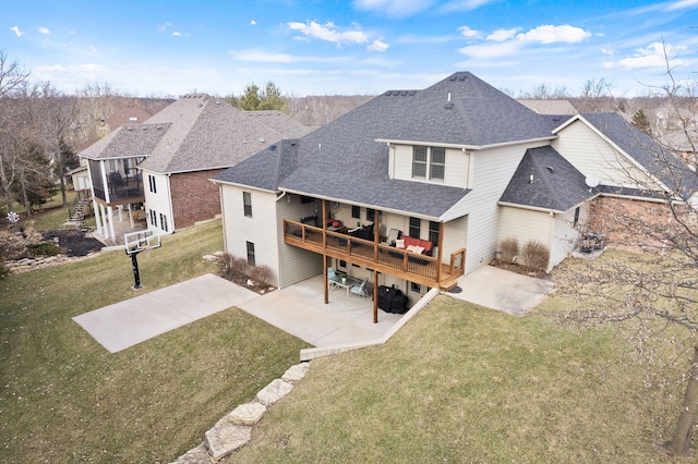 back of house featuring a patio area, a shingled roof, a deck, and a lawn