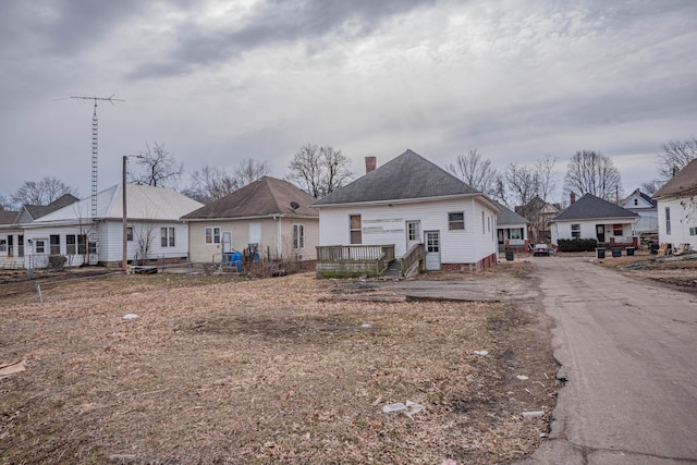 back of house with a residential view and a chimney