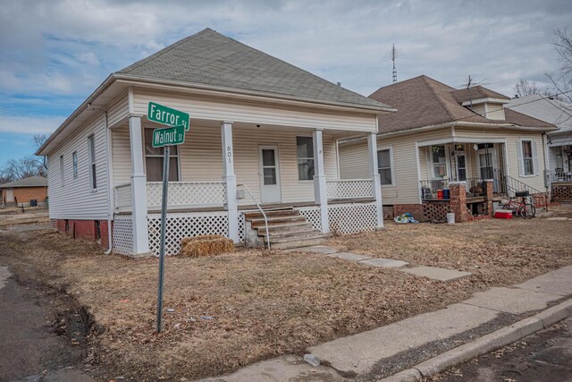 bungalow-style home with a shingled roof and a porch