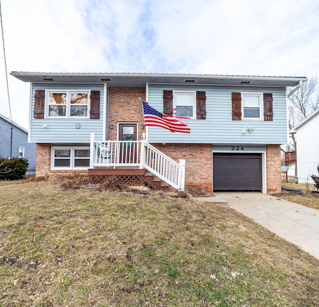 raised ranch with brick siding, metal roof, a garage, driveway, and a front lawn