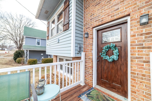 doorway to property featuring brick siding