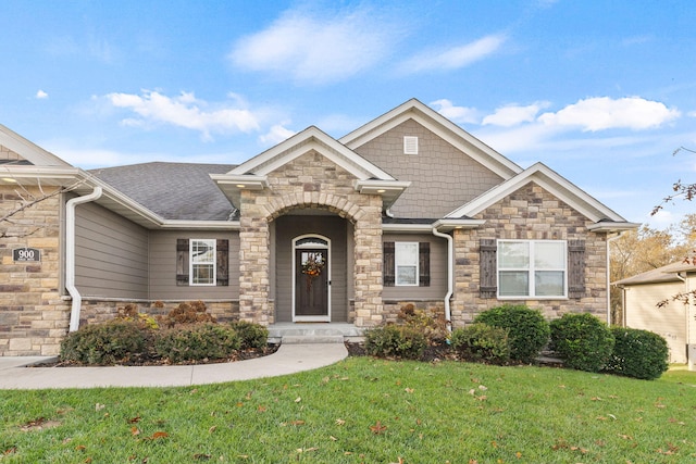 craftsman-style home featuring a shingled roof and a front lawn