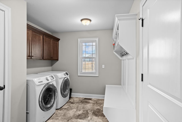 laundry room featuring cabinet space, baseboards, and separate washer and dryer