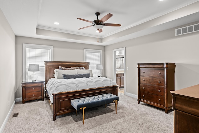 bedroom with light carpet, visible vents, baseboards, a tray ceiling, and multiple windows