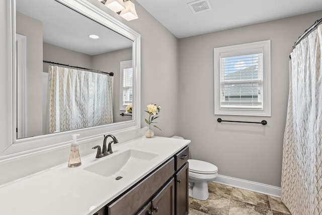 bathroom featuring visible vents, toilet, vanity, and baseboards