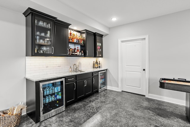 bar with wine cooler, indoor wet bar, a sink, and baseboards