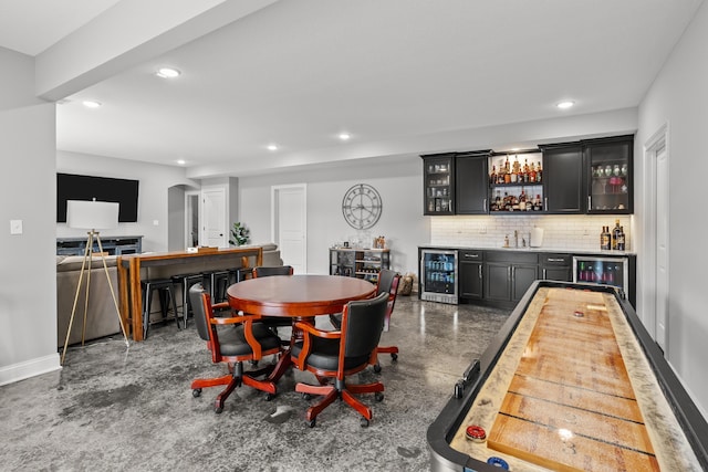 dining area featuring wine cooler, indoor wet bar, finished concrete flooring, and recessed lighting