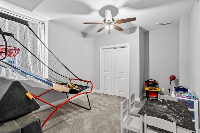 game room with a textured ceiling, carpet floors, visible vents, and baseboards