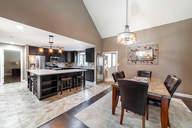 dining room featuring high vaulted ceiling, recessed lighting, and baseboards