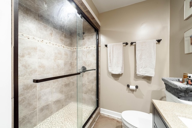 full bathroom featuring a stall shower, vanity, toilet, and baseboards