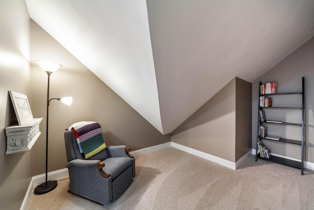 living area featuring baseboards, vaulted ceiling, and carpet flooring