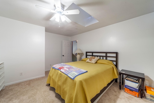 carpeted bedroom featuring a ceiling fan, a skylight, and baseboards