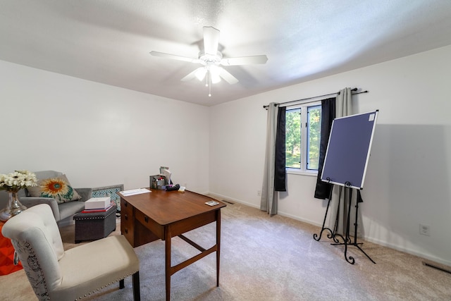 home office with a ceiling fan, light carpet, visible vents, and baseboards