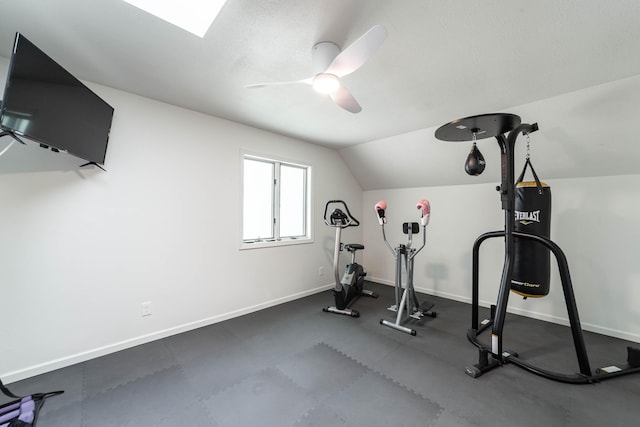 exercise room with vaulted ceiling, baseboards, and ceiling fan