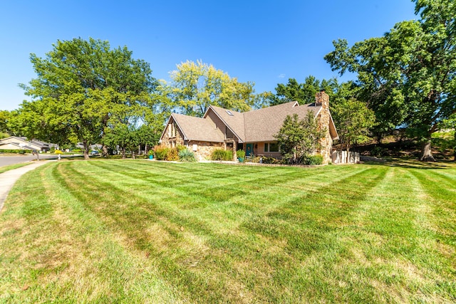 view of property exterior featuring stone siding, a chimney, and a yard