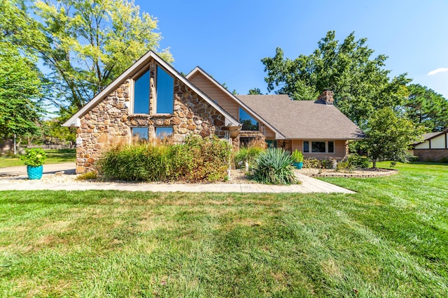 view of front of property featuring stone siding, a chimney, and a front yard